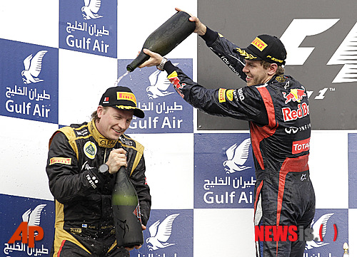 【사키르(바레인)=AP/뉴시스】레드불의 세바스찬 베텔(25·독일·사진 오른쪽)이 22일 바레인 사키르에서 열린 2012 F1 바레인 그랑프리에서 우승한 뒤 로터스의 키미 라이코넨(33·핀란드)에게 샴페인을 뿌리며 자축하고 있다.&nbsp; 