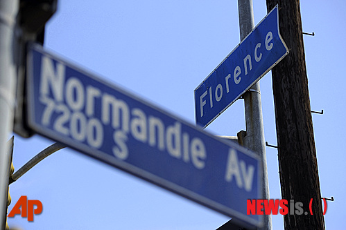 【로스앤젤레스=AP/뉴시스】17일(현지시간) 촬영한 사진으로 미국 캘리포니아 로스앤젤레스(LA) 남중부에 있는 플로렌스와 노만디 애비뉴를 통과하는 교차로 앞에 표지판이 보이고 있다. 이 교차로는 지난 1992년 4월29일 LA 폭동이 본격적으로 일어났던 곳으로 당시 백인 트럭 운전사였던 레지널드 데니가 폭도들로부터 무차별적인 폭행을 당했다. LA 폭동은 당시 청년이었던 흑인 로드니 킹을 집단 구타한 백인 경찰관 4명이 무죄 판결을 받으면서 촉발됐다. LA 폭동으로 자동차가 파손되고 상점이 불에 타는 등 혼란스러운 상황이 연출됐다. LA 폭동으로 55명이 사망하고 2300명이 부상했으며 건물 1500채가 파괴되거나 유리창이 깨지는 피해가 발생했다.