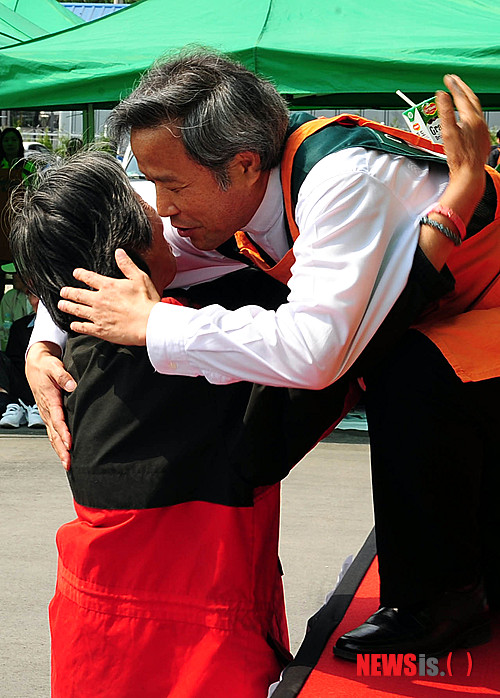 【서울=뉴시스】박문호 기자 = 어버이날인 8일 오전 서울 동대문구 답십리동 밥퍼 운동본부 앞마당에서 열린 '밥퍼 효도 잔치'에서 최일도 목사(오른쪽)가 어르신을 안아 드리고 있다. 다일공동체(대표 최일도 목사)는 24년째 노숙인, 행려자, 무의탁 노인에게 매일 무료급식을 하고 있다.&nbsp; go2@newsis.com