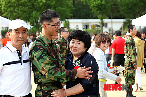 【광주=뉴시스】맹대환 기자 = 어버이날인 8일 광주 북구 육군 31사단 신병교육대대 연병장에서 어버이날을 맞이 입영문화제가 열린 가운데 한 입대 장병이 부모님께 카네이션을 달아주고 있다.(사진=31사단 제공)&nbsp;&nbsp; mdhnews@newsis.com