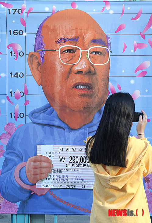 【광주=뉴시스】안현주 기자 = 제32주년 5·18민중항쟁 기념식을 하루 앞둔 17일 오후 광주 동구 금남로 전야제 행사장에서 한 시민이 전두환 전 대통령을 풍자한 그림을 카메라에 담고 있다.&nbsp; ahj@newsis.com 