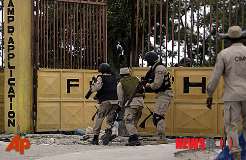 【포르토프랭스=AP/뉴시스】아이티 수도 포르토프랭스에서 경찰이 19일(현지시간) 해산됐던 군대의 일원을 체포하기 위해 과거 군 기지로 사용하다 폐쇄된 기지를 침투하고 있다. 아이티 정부 관계자는 경찰이 해산한 군인들이 작전기지로 사용한 이전 군부대 2곳을 급습했다고 밝혔다. 전날 신병 지원자들이 포르토프랭스를 행진하며 군부대 해산 철회를 요구하자 정부가 이 기지들을 폐쇄했다. 