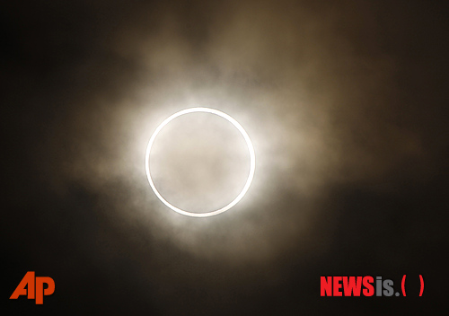  【요코하마 =AP/뉴시스】21일 일본 요코하마(橫濱)의 상공에 나타난 희귀한 반지 모양의 금환일식이 신비한 느낌을 더해주고 있다. 이날 수백만의 아시아인들은 달이 태양을 가리는 일식을 볼 수 있었다. 