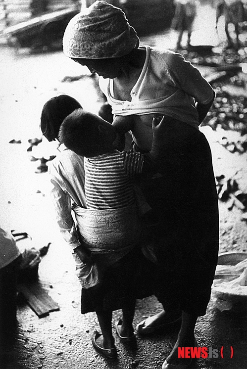 【서울=뉴시스】유상우 기자 = 다큐멘터리 1세대 사진가 최민식(84)의 사진은 살아있다. 꾸며내거나 조작하지 않는다. 특히 체험이 더해져 인간적이다.&nbsp; 작가가 포착한 사진은 1950~1970년대 힘없고 소외된 사람들의 남루한 일상이다. 부산 자갈치시장에서 아낙네가 하던 일을 멈추고 선 채로 아이에게 젖을 먹이는 모습, 국수를 먹고 있는 아이를 따뜻하게 바라보는 엄마와 할머니, 우는 동생의 눈물을 닦아주는 어린 누이, 판잣집에 기대어 말뚝박기를 하는 아이들의 함성, 남부끄러운지 모르고 홀딱 벗은 채 카메라를 향해 지은 어린이들의 함박웃음….&nbsp; 최옹은 "사진은 있는 그대로의 모습을 담아야 한다. 무엇보다 모든 예술이 그렇듯이 체험이 없으면 살아있는 사진을 찍을 수 없다"고 지적한다. "인간은 애환이 있다. 촬영 대상을 발견하는 동시에 기쁨과 슬픔이 담긴 그 표정을 읽어야 한다. 그런 삶에 대해 어느 정도 알아야 가능하다"는 것이다.&nbsp; 경북 안동 출생인 그는 어린 시절 황해도 연백에서 소작농으로 일하는 아버지 밑에서 가난을 겪으며 자랐다. 평남 진남포에서 미쓰비시 기능자양성소 기능교육을 수료하고 자동차기능공으로 일했다. 이후 서울로 올라와 낮에는 과자공장에서 막일을 하고 밤에는 미술학원에 다니며 화가의 꿈을 키웠다. 6·25동란이 끝나자 일본으로 밀항, 도쿄중앙미술학원에 들어가 2년 동안 미술공부를 했다.&nbsp; 그곳에서 우연히 접한 에드워드 스타이켄의 사진집에 매료돼 독학으로 사진을 공부하며 사람을 소재로 카메라를 들이댔다. 새마을운동이 한창이던 시절에는 거지나 가난에 찌든 사진만 찍어 외국에 전시하는 그를 못마땅하게 여긴 박정희 정권의 박해를 받기도 했다.&nbsp; "내 사진을 보고 '그 정도는 찍을 수 있다'고 하는데 쉽지 않다. 학생들도 내 사진을 보면 찍을 수 있을 것 같다고 자신하지만 막상 자신의 결과물을 보고는 맛이 안 난다고 한다. 그것은 체험이 없기 때문이다. 나는 가난하게 살았기 때문에 이런 사진을 찍을 수 있다"고 전했다. 지게꾼·넝마주이·군고구마 장수 등 안 해본 일이 없다.&nbsp; 그가 서울 소공동 롯데백화점 본점 롯데갤러리에 '소년시대'라는 제목으로 작품을 걸었다. 1957년 이후의 부산 자갈치시장과 광안리 해변, 영도 골목, 부산역 등을 배경으로 한 사진 150점을 내놨다. 이 가운데 120점은 처음으로 발표한 사진이다.&nbsp; 작가의 모든 자료는 국가기록원이 소장하고 있다. 2008년 자신의 사진 원판 10만여장 등 13만여점의 자료를 국가기록원에 내놔 민간 기증 국가기록물 제1호로 지정됐다.&nbsp; 롯데갤러리는 이번 전시를 위해 국가기록원에 있는 10만장의 필름 가운데 전시 주제에 맞는 어린이 필름을 고르고, 스캔하고, 프린트하는 과정을 거쳐야 했다.&nbsp; 작가는 "인화가 매우 잘됐다. 내가 못 본 사진도 많다. 다른 사람이 찍은 사진이라는 생각이 들 정도"라며 웃었다.&nbsp; 최옹은 올가을 사진집 시리즈 1집부터 14집 가운데 800여점을 골라 책으로 펴낼 예정이다. 내년에는 15집을 낼 생각이다. 자금이 마련되면 아프리카 난민들의 생활상도 찍고 싶다. "아프리카 중부 지역에 가면 난민들이 모여 사는 천막이 1000개나 되는 곳이 있다고 한다. 이들의 모습을 찍고 사진전도 하고 책도 만들고 모금운동도 해볼까 생각 중"이라며 노익장을 과시했다.&nbsp; 우리 나이로 여든다섯이다. "아직 눈과 귀가 밝다. 걸음걸이도 빠르다. 이것은 하나님이 나에게 사진을 더 찍으라고 혜택을 준 것이다. 감사하게 생각하고 죽을 때까지 사진을 찍을 것이다. 18집까지 만들 수 있지 않겠느냐는 생각을 한다."&nbsp; 전시는 7월8일까지다. 02-726-4428&nbsp; swryu@newsis.com