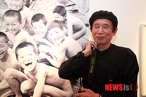 【서울=뉴시스】유상우 기자 = 다큐멘터리 1세대 사진가 최민식(84)의 사진은 살아있다. 꾸며내거나 조작하지 않는다. 특히 체험이 더해져 인간적이다.&nbsp; 작가가 포착한 사진은 1950~1970년대 힘없고 소외된 사람들의 남루한 일상이다. 부산 자갈치시장에서 아낙네가 하던 일을 멈추고 선 채로 아이에게 젖을 먹이는 모습, 국수를 먹고 있는 아이를 따뜻하게 바라보는 엄마와 할머니, 우는 동생의 눈물을 닦아주는 어린 누이, 판잣집에 기대어 말뚝박기를 하는 아이들의 함성, 남부끄러운지 모르고 홀딱 벗은 채 카메라를 향해 지은 어린이들의 함박웃음….&nbsp; 최옹은 "사진은 있는 그대로의 모습을 담아야 한다. 무엇보다 모든 예술이 그렇듯이 체험이 없으면 살아있는 사진을 찍을 수 없다"고 지적한다. "인간은 애환이 있다. 촬영 대상을 발견하는 동시에 기쁨과 슬픔이 담긴 그 표정을 읽어야 한다. 그런 삶에 대해 어느 정도 알아야 가능하다"는 것이다.&nbsp; 경북 안동 출생인 그는 어린 시절 황해도 연백에서 소작농으로 일하는 아버지 밑에서 가난을 겪으며 자랐다. 평남 진남포에서 미쓰비시 기능자양성소 기능교육을 수료하고 자동차기능공으로 일했다. 이후 서울로 올라와 낮에는 과자공장에서 막일을 하고 밤에는 미술학원에 다니며 화가의 꿈을 키웠다. 6·25동란이 끝나자 일본으로 밀항, 도쿄중앙미술학원에 들어가 2년 동안 미술공부를 했다.&nbsp; 그곳에서 우연히 접한 에드워드 스타이켄의 사진집에 매료돼 독학으로 사진을 공부하며 사람을 소재로 카메라를 들이댔다. 새마을운동이 한창이던 시절에는 거지나 가난에 찌든 사진만 찍어 외국에 전시하는 그를 못마땅하게 여긴 박정희 정권의 박해를 받기도 했다.&nbsp; "내 사진을 보고 '그 정도는 찍을 수 있다'고 하는데 쉽지 않다. 학생들도 내 사진을 보면 찍을 수 있을 것 같다고 자신하지만 막상 자신의 결과물을 보고는 맛이 안 난다고 한다. 그것은 체험이 없기 때문이다. 나는 가난하게 살았기 때문에 이런 사진을 찍을 수 있다"고 전했다. 지게꾼·넝마주이·군고구마 장수 등 안 해본 일이 없다.&nbsp; 그가 서울 소공동 롯데백화점 본점 롯데갤러리에 '소년시대'라는 제목으로 작품을 걸었다. 1957년 이후의 부산 자갈치시장과 광안리 해변, 영도 골목, 부산역 등을 배경으로 한 사진 150점을 내놨다. 이 가운데 120점은 처음으로 발표한 사진이다.&nbsp; 작가의 모든 자료는 국가기록원이 소장하고 있다. 2008년 자신의 사진 원판 10만여장 등 13만여점의 자료를 국가기록원에 내놔 민간 기증 국가기록물 제1호로 지정됐다.&nbsp; 롯데갤러리는 이번 전시를 위해 국가기록원에 있는 10만장의 필름 가운데 전시 주제에 맞는 어린이 필름을 고르고, 스캔하고, 프린트하는 과정을 거쳐야 했다.&nbsp; 작가는 "인화가 매우 잘됐다. 내가 못 본 사진도 많다. 다른 사람이 찍은 사진이라는 생각이 들 정도"라며 웃었다.&nbsp; 최옹은 올가을 사진집 시리즈 1집부터 14집 가운데 800여점을 골라 책으로 펴낼 예정이다. 내년에는 15집을 낼 생각이다. 자금이 마련되면 아프리카 난민들의 생활상도 찍고 싶다. "아프리카 중부 지역에 가면 난민들이 모여 사는 천막이 1000개나 되는 곳이 있다고 한다. 이들의 모습을 찍고 사진전도 하고 책도 만들고 모금운동도 해볼까 생각 중"이라며 노익장을 과시했다.&nbsp; 우리 나이로 여든다섯이다. "아직 눈과 귀가 밝다. 걸음걸이도 빠르다. 이것은 하나님이 나에게 사진을 더 찍으라고 혜택을 준 것이다. 감사하게 생각하고 죽을 때까지 사진을 찍을 것이다. 18집까지 만들 수 있지 않겠느냐는 생각을 한다."&nbsp; 전시는 7월8일까지다. 02-726-4428&nbsp; swryu@newsis.com