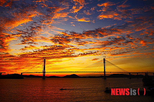 【목포=뉴시스】박상수 기자 = 29일 개통을 앞둔 목포대교가 석양에 물들어 장관을 이루고 있다. 전남 목포시 북항과 고하도를 연결하는 목포대교는 국내 최초 '3웨이 케이블 공법'을 적용해 건설됐으며, 총연장은 4.129㎞이다. 목포시는 목포대교가 전남 서남권 물류 수송의 대변화를 가져오고 목포의 랜드마크가 될 것으로 기대된다고 27일 밝혔다.(사진=목포시 제공)  photo@newsis.com