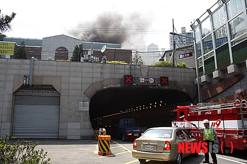 【부산=뉴시스】하경민 기자 = 28일 오후 2시19분께 부산 남구 황령터널 안에서 전포동 방면으로 달리던 2.5t 트럭이 앞서가던 액센트 승용차를 들이받는 바람에 차량 7대가 잇따라 추돌하는 사고가 났다. 이 사고로 다행히 인명피해는 없었지만 액센트 승용차가 전소됐고, 트럭의 절반 정도 태운 뒤 20여분 만에 출동한 소방대원들에 의해 진화됐다. 사진은 터널 입구에 화재로 인해 연기가 새어나오는 모습. (사진=부산경찰청 제공)&nbsp; yulnetphoto@newsis.com