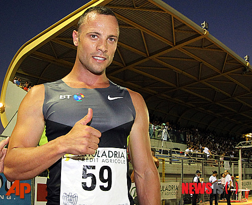 Double-amputee sprinter, South African Oscar Pistorius, poses for photographers at the end of a 400 meter race in Lignano Stadium, near Udine, northern Italy, Tuesday, July 17, 2012. Pistorius, known globally as the Blade Runner, will be running the 400 meters race at the London 2012 Olympic Games. The South African was selected by his country as the first amputee athlete to run at the Olympics and wants desperately to prove himself at the games after eventually being cleared to run against able-bodied athletes on his blades. (AP Photo/Paolo Giovannini) 