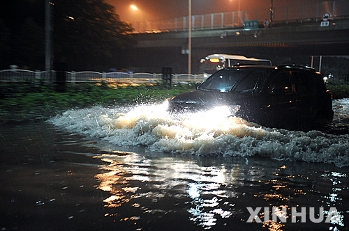 【베이징=신화/뉴시스】22일 새벽 중국 수도 베이징 거리의 침수된 도로에서 자동차가 힘겹게 물살을 헤치며 운행하고 있다. 60년만의 폭우로 기록된 이번 비로 베이징 시내에서만 최소 10명의 사상자가 발생했다.&nbsp; 