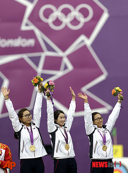 【런던=AP/뉴시스】한국 여자 양궁 국가대표 선수 기보배, 최현주, 이성진이 29일(현지시간) 여자 양궁 단체전에서 중국을 꺾고 금메달을 획득한 뒤 시상대에서 기뻐하고 있다. 