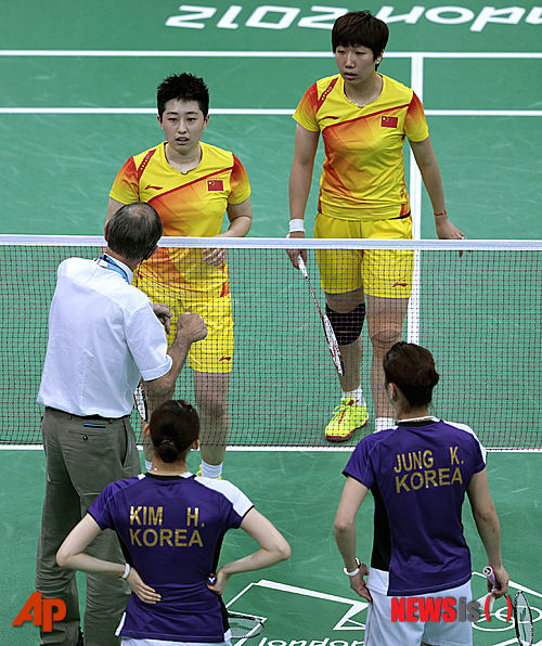 【런던=AP/뉴시스】31일(현지시간) 배드민턴 여자복식 A조 조별예선 3차전 한국과 중국 경기에서 심판이 세계 랭킹 1위인 중국의 왕샤오리-위양조에게 말하고 있고 한국의 정경은-김하나조는 이를 듣고 있다. 양 팀은 이날 웸블리 에레나에서 열린 예선전에서 쉬운 상대를 만나기 위해 '져주기 게임'을 연출했다는 의혹을 받고 있다. 관중들은 선수들의 성의 없는 게임에 야유를 퍼부었다.
