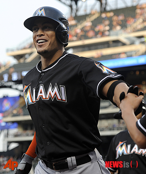 Miami Marlins' Giancarlo Stanton is congratulated by the bat boy after hitting a two-run home run against the New York Mets in the first inning of a baseball game in New York, Wednesday, Aug. 8, 2012. (AP Photo/Henny Ray Abrams)