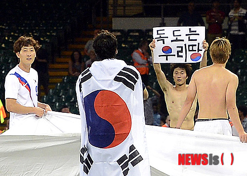 【카디프(영국)=뉴시스】서재훈 기자 = 10일(현지시간) 저녁 영국 카디프 밀레니엄 스타디움에서 런던올림픽 축구 한국 축구 올림픽대표팀과 일본 대표팀과의 3-4위 결정전이 열린 가운데 대한민국이 일본을 2:0으로 완파하고 동메달을 확정, 선수들이 대형 태극기를 들고 박종우(오른쪽 두번째) 선수가 '독도는 우리땅' 손 피켓을 들어보이고 있다.&nbsp; jhseo@newsis.com