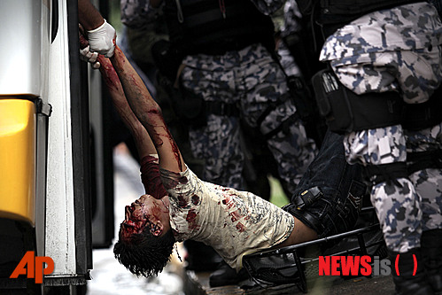  【베라크루스(멕시코) =AP/뉴시스】18일 멕시코의 베라크루스에서 경찰이 한 버스에서 마약 카르텔에 피살된 남자의 시신을 끌어내고 있다. 경찰은 범인이 버스에 타고 가다 범행을 저지른 후 도망쳤다고 말했다.