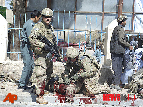  【 AP/뉴시스】일찌기 버락 오바마 미국 대통령이 '필연의 전쟁'이라고 했던 아프가니스탄 전쟁은 지금도 많은 희생자들을 내고 있으나 미국인들에게는 '잊혀진 전쟁'이 됐다. 사진은 지난 4월4일 파라아브주 주도 마이마나에서 자살폭탄 공격으로 죽은 미군 병사의시체를 동료가 바로 누이고 있는 모습이다.&nbsp; 