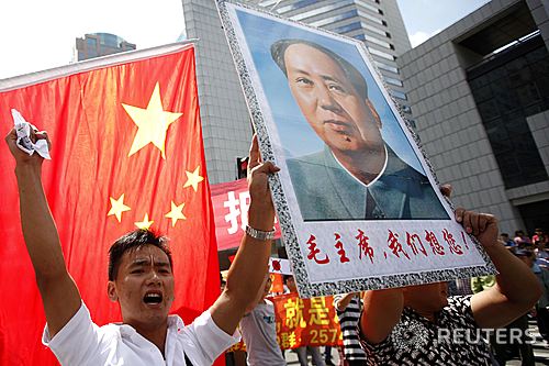 댜오위다오(釣魚島·일본명 센카쿠尖閣) 영유권 충돌로 중국에서 반일 감정이 격화된 가운데 9월16일 상하이 도심에서 시위대가 사망한 지 오래된 공산혁명 지도자인 마오쩌둥의 초상화를 들고 시위를 벌이고 있다. <상하이=로이터/뉴시스>