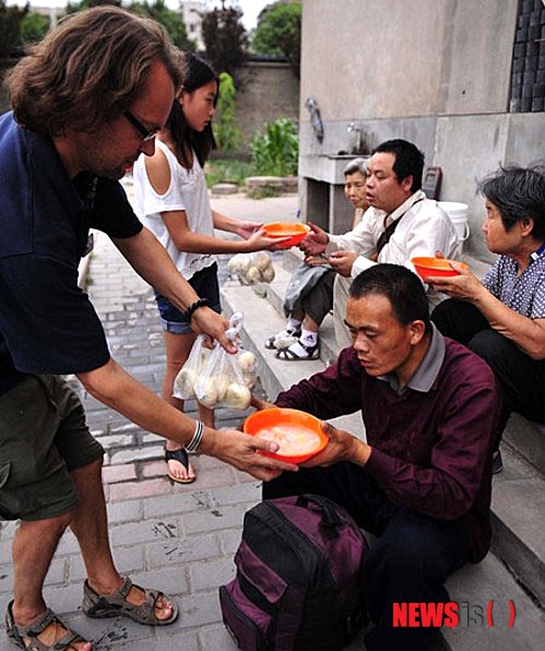 【서울=뉴시스】지난 19일 영국 엔지니어 출신의 토니가 산시(陝西)성 시안(西安)의 많은 노숙자들을 위해 무료 식사를 제공하는 일명 '밥퍼' 자선 봉사를 하고 있다. 우연한 기회에 중국 노숙자들에게 자선을 베푼 것을 계기로 7년 동안 자선 봉사를 지속해 오고 있는 그의 사연이 알려지면서 큰 파장을 일으키고 있다.(사진출처: 화상바오(華商報))
