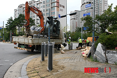【용인=뉴시스】이정하 기자 = 27일 경기 용인시 기흥구 중동 동백도서관 인근 교차로에서 작업 인부들이 보행로에 설치된 멀쩡한 석재 볼라드를 철거하고, 부딪혀도 충격이 덜한 원형 모형의 탄성 볼라드로 교체하는 공사를 하고 있다.&nbsp; jungha98@newsis.com 
