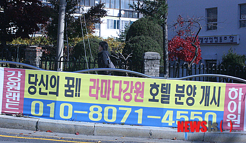 【정선=뉴시스】홍춘봉 기자 = 강원 정선군 강원랜드 입구에 들어설 수익형 호텔분양이 적법성 논란을 빚고 있는 가운데 태백시가지에 부착된 호텔분양 홍보현수막 옆을 한 주민이 지나가고 있다.&nbsp; casinohong@newsis.com 