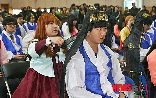 【증평=뉴시스】강신욱 기자 = 13일 충북 증평군 형석고등학교 강당에서 열린 32회 졸업식에서 졸업하는 여학생이 남학생의 두건을 고쳐주고 있다.&nbsp; ksw64@newsis.com