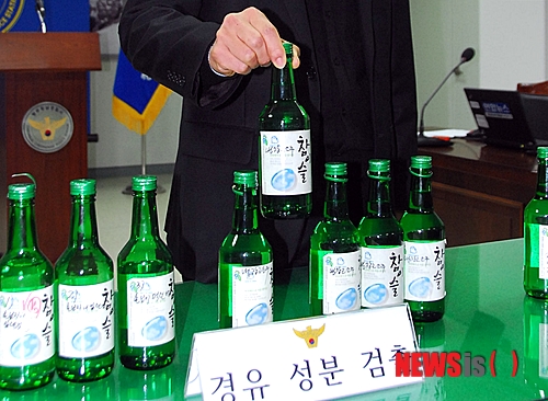 【청주=뉴시스】엄기찬 기자 = 경찰은 8일 하이트진로 '참이슬' 소주의 경유 성분 검출과 관련해 "생산과정에서는 이것이 들어갈 가능성이 없다"고 밝혔다. 이날 오전 충북 청주청남경찰서에서 열린 브리핑에서 경찰이 경유 성분이 검출된 소주를 들어보이고 있다. dotor0110@newsis.com