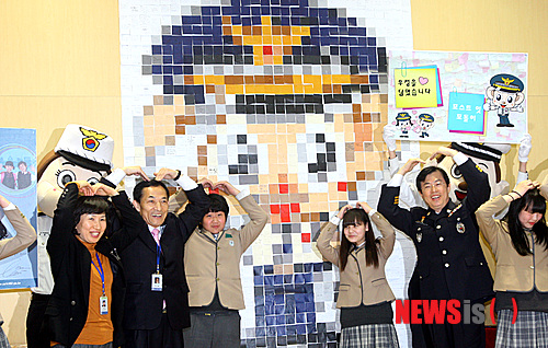 【수원=뉴시스】강종민 기자 = 16일 오후 경기 수원 창용중학교에서 이만희 경기경찰청장과 학생들이 학교폭력 근절을 염원하는 글이 적힌 포스트잇 1320장으로 대형 포돌이를 만든 뒤 하트를 만들고 있다. ppkjm@newsis.com 