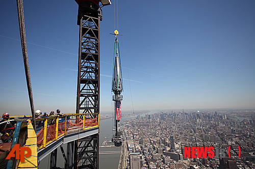 【뉴욕=AP/뉴시스】9·11 테러 현장 옆에 신축된 세계 무역센터 빌딩 현장에서 2일 맨 꼭대기 옥상 위에 세워질 첨탑의 2개 부분이 성조기에 싸인 채 끌어올려지고 있다. 미 독립을 기념하는 1776피트(541m)의 이 빌딩은 미국내 최고 높이를 자랑하는 첨단 건물로 2014년 개관한다.