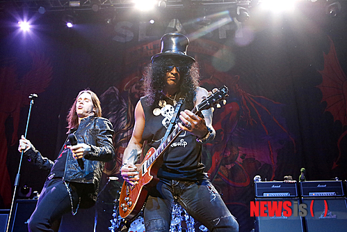 【서울=뉴시스】이재훈 기자 = 깁슨 레스폴 기타는 포효하거나 그르릉거렸다. 짐승 기타리스트 슬래시(48)가 조련하는 기타다웠다.&nbsp;&nbsp; 자신의 상징처럼 된 영국의 신사 모자 같은 '탑햇(top hat)'과 선글라스를 쓰고 미키 마우스가 그려진 검은 색 민 소매 티셔츠를 입은 슬래시가 매만질 때마다 기타는 울부짖었다.&nbsp;&nbsp; 특히, '로켓 퀸(Rocket Queen)'을 연주할 때 그의 짐승다움이 도드라졌다. 육중한 팔 근육이 꿈틀거리면서 기타를 튕길 때 짐승을 넘어 날 것의 무엇인가를 보여줬다.&nbsp; 중국 전통 악기 비파를 연주하듯 기타를 거의 수직으로 세워서 매만지는 그의 모습이 전면에 드러났다. 이 곡을 연주한 총 15여분 중 약 10분을 자신의 밴드 앞에 홀로 나와 실력을 과시했다. 손가락으로 누르는 대신 슬라이드 바를 사용해 줄 위를 매끄럽게 타는 기타 주법인 슬라이드를 잠깐 선보이기도 했다.&nbsp;&nbsp; 2011년 첫 단독 공연 이후 약 2년2개월 만에 내한, 9일 밤 서울 광장동 유니클로 악스에서 2번째 솔로 공연을 선보인 슬래시 무대의 절정은 '로켓 퀸'을 비롯해 그가 몸 담은 미국의 세계적인 헤비메탈 밴드 '건스 앤 로지스(Guns N' Roses)'의 곡들을 들려줄 때였다.&nbsp; '헤일로(halo)'로 포문을 여는 등 지난해 발매한 2번째 솔로 앨범 '아포칼립틱 러브'를 기념하는 투어였지만 건스 앤 로지스의 노래들이 흘러나올 때 1500여 팬들의 환호성도 더 크게 터져나왔다.&nbsp;&nbsp; 역대 최고의 기타 도입 리프(riff) 중 하나로 손꼽히는 건스 앤 로지스의 '스위트 차일드 오 마인(Sweet Child O' Mine)'는 화룡점정이었다. 2층 지정석의 팬들도 모두 일어났다. 노래 뿐만 아니라 전주, 간주, 후주의 멜로디까지 '떼창'하는 마니아들의 모습이 인상적이었다.&nbsp; 앙코르 역시 본 공연 못지 않았다. '웰컴 투 더 정글(Welcome to the Jungle)' '파라다이스 시티(Paradise City) 등 역시 슬래시의 기타 리프를 통해 귀에 익은 건스 앤 로지스의 곡들도 공연장은 들썩였다.&nbsp; 실제 슬래시는 1980년대 말부터 1990년대 초까지 건스 앤 로지스의 전성기의 주역이다. 결성 24년 만인 지난 2009년 12월 건스 앤 로지스의 첫 내한 공연은 명성에 살짝 못 미친 감이 있었다. 팬들을 무려 2시간20분 간 기다리게 하는 등 악동 기질은 여전했으나 원년 멤버가 보컬 액슬 로즈(51)밖에 남아 있지 않았다는 점에서 어찌 보면 당연한 수순이었다.&nbsp;&nbsp; 슬래시의 이날 공연은 일면 건스 앤 로지스의 내한공연 때보다 더 건스 앤 로지스의 공연 같았다는 점에서 록기운이 충만했다.&nbsp;&nbsp; 슬래시 뿐 아니라 밴드 자체의 실력도 상당했다. 특히 지난 슬래시의 첫 내한공연 때도 함께 했던 보컬 마일스 케네디(44)는 특유의 쇳소리로 고음을 무난히 소화하면서 화려한 무대 매너까지 뽐냈다.&nbsp; 가타부타 특별한 말을 꺼내지 않은 슬래시는 약 2시간 남짓한 공연 내내 카리스마를 잃지 않았을 뿐 아니라 쉰에 가까운 나이에도 섹시함을 자랑했다. 슬래시를 포함한 밴드의 강렬한 연주가 끝난 뒤 잔향처럼 남은 하울링 사운드가 청중의 아쉬운 발길을 배웅했다.&nbsp; 이날 오프닝 무대는 시원하고 강렬한 연주력이 인상적인 펑크록 밴드 '옐로우 몬스터즈'가 꾸몄다. 모던 록 1세대 밴드로 통하는 '델리 스파이스'의 드러머 최재혁(38)과 '마이 앤트 메리'의 베이시스트 한진영(37), 펑크 밴드 '검엑스'의 이용원(33)이 의기투합한 밴드는 슬래시와 기념사진을 남기기도 했다.&nbsp; 애초 슬래시와 옐로우 몬스터즈는 이날 세계적인 얼터너티브 메탈밴드 '데프톤스'와 함께 '메탈페스트 2013'을 펼치려고 했다. 그러나 데프톤스가 팀 사정으로 내한을 포기하면서 슬래시 단독 공연의 모양새를 갖추게 됐다. 하지만 이날 공연은 데프톤스의 불참에 대한 아쉬움을 충분히 달랠 만했다.&nbsp; 공연이 끝난 뒤 자신의 기타 피크를 객석에 나눠준 슬래시는 자신의 트위터에 "서울의 오늘밤은 군중이 죽여줬다! 심하게 좋은 시간이었다!"(KILLER crowd in Seoul tonight! Good fxxking times!)고 남겼다. 내한 공연 직전 e-메일을 통해 "한국팬들은 지금껏 내 공연을 찾아온 팬들 중 최고"라고 전했던 그의 말이 하울링처럼 남았다.&nbsp; <사진> 액세스 ENT 제공&nbsp;&nbsp; realpaper7@newsis.com 