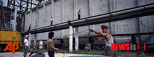  【함흥=AP/뉴시스】지난 2012년 8월10일 북한 함흥의 한비료공장에서 북한 노동자들이 일하고 있다. 러시아 정부는 9000명이 넘는 북한 노동자들에 대해 노동 허가를 내달라는 극동 연해주 정부의 요청을 거부, 노동 허가를 내주지 않기로 결정했다고 러시아 언론이 전했다. 이는 북한 노동자의 노동을 금지한 유엔 안보리 제재에 따른 것이다. 2017.12.29 