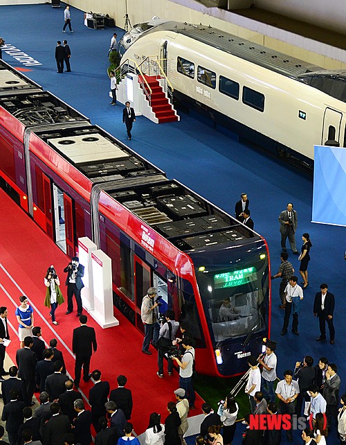 【부산=뉴시스】 하경민 기자 = 12일 오전 부산 벡스코에서 열린 '부산국제철도 및 물류산업전'을 찾은 관람객들이 기존 동력원인 전기 외 차량에 장착된 배터리를 동력원으로 해 유가선 및 무가선으로 주행하는 '저상트램'의 실차로 구경하고 있다. 사진 오른쪽은 일반에 첫 공개된 시속 430㎞급 차세대 고속열차인 'HEMU-430X' 시제차량.  세계 철도.물류 산업의 신기술을 한자리에 모은 이번 전시에는 20개국 158개 글로벌 기업이 참가했다. 행사는 15일까지 계속된다. 2013.06.12.  yulnetphoto@newsis.com 