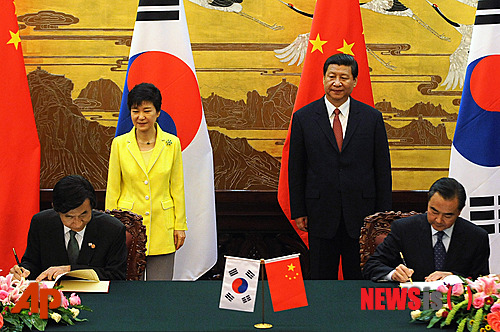 【베이징=AP/뉴시스】박근혜 대통령과 시진핑(習近平) 중국 국가주석이 27일 오후 중국 베이징 인민대회당에서 정상회담 공동기자회견 전 양국 사인식을 보며 미소짓고 있다. 2013.06.27.