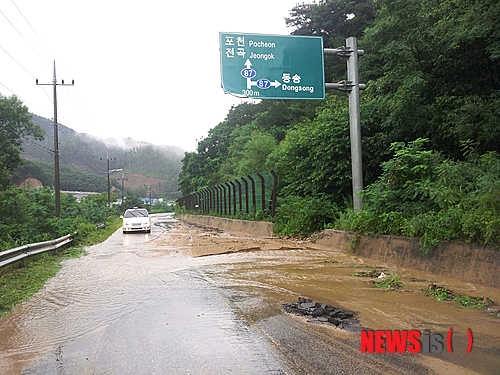 【포천=뉴시스】이종구 기자 = 15일 오전 시간당 30mm의 국지성 폭우가 쏟아지며 이날 오후 2시까지 누적 강수량이 144.5mm를 기록한 경기 포천시 전곡방면 도로에 토사가 덮쳐 차량 통행이 불편을 초래하고 있다. 2013.07.15 (사진=포천시청 제공)&nbsp;&nbsp;&nbsp;&nbsp;&nbsp; leejg@newsis.com 