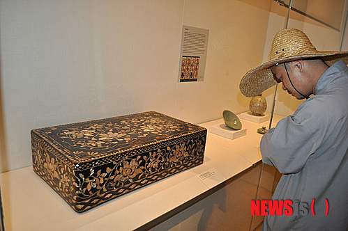 【뉴욕=뉴시스】노창현 특파원 = 조선조 왕이 집무할 때 입는 곤룡포(袞龍袍)를 보관하는 ‘용무늬 대례복함’이 사상 처음 발견됐다. 문화재제자리찾기 대표 혜문 스님은 14일 뉴욕 메트로폴리탄 박물관의 한국관에 전시 중인 ‘용장식 의복함’이 왕의 정복(正服)을 보관하는 함인 것을 확인했다고 밝혔다. 용장식 대례복함은 겉면이 두 마리의 용이 빛을 발산하는 중앙의 여의주를 향해 온 몸을 비틀며 날아드는 형상으로 전형적인 왕권을 상징하고 있다. 혜문 스님과 경희대 역사학과 김준혁 교수는 13일 박물관을 방문, 용장식 대례복함의 존재를 처음 확인한 후 이튿날 ‘조선의 마지막 공주’로 불리는 이해경 여사와 미주불교문화원 김정광 원장을 동반, 진품임을 재확인했다. 용장식 의복함과 함께 발견된 '모란작약 무늬 의복함'을 혜문 스님이 주의깊게 살펴보고 있다. 2013.07.14. <사진=Newsroh.com 제공> robin@newsis.com