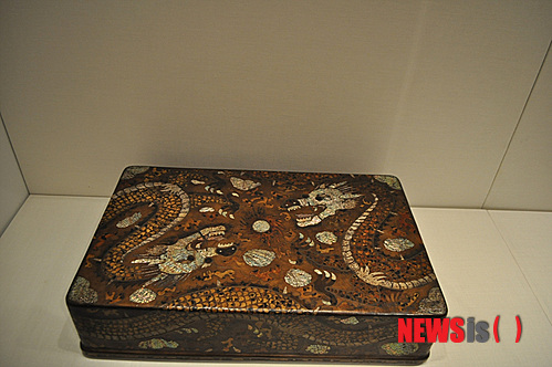 【뉴욕=뉴시스】노창현 특파원 = 조선조 왕이 집무할 때 입는 곤룡포(袞龍袍)를 보관하는 ‘용무늬 대례복함’이 사상 처음 발견됐다. 문화재제자리찾기 대표 혜문 스님은 14일 뉴욕 메트로폴리탄 박물관의 한국관에 전시 중인 ‘용장식 의복함’이 왕의 정복(正服)을 보관하는 함인 것을 확인했다고 밝혔다. 용장식 대례복함은 겉면이 두 마리의 용이 빛을 발산하는 중앙의 여의주를 향해 온 몸을 비틀며 날아드는 형상으로 전형적인 왕권을 상징하고 있다. 혜문 스님과 경희대 역사학과 김준혁 교수는 13일 박물관을 방문, 용장식 대례복함의 존재를 처음 확인한 후 이튿날 ‘조선의 마지막 공주’로 불리는 이해경 여사와 미주불교문화원 김정광 원장을 동반, 진품임을 재확인했다. 2013.07.14. <사진=Newsroh.com 제공> robin@newsis.com