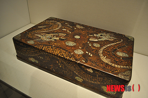 【뉴욕=뉴시스】노창현 특파원 = 조선조 왕이 집무할 때 입는 곤룡포(袞龍袍)를 보관하는 ‘용무늬 대례복함’이 사상 처음 발견됐다. 문화재제자리찾기 대표 혜문 스님은 14일 뉴욕 메트로폴리탄 박물관의 한국관에 전시 중인 ‘용장식 의복함’이 왕의 정복(正服)을 보관하는 함인 것을 확인했다고 밝혔다. 용장식 대례복함은 겉면이 두 마리의 용이 빛을 발산하는 중앙의 여의주를 향해 온 몸을 비틀며 날아드는 형상으로 전형적인 왕권을 상징하고 있다. 혜문 스님과 경희대 역사학과 김준혁 교수는 13일 박물관을 방문, 용장식 대례복함의 존재를 처음 확인한 후 이튿날 ‘조선의 마지막 공주’로 불리는 이해경 여사와 미주불교문화원 김정광 원장을 동반, 진품임을 재확인했다. 2013.07.14. <사진=Newsroh.com 제공> robin@newsis.com