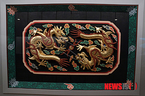 【뉴욕=뉴시스】노창현 특파원 = 조선조 왕이 집무할 때 입는 곤룡포(袞龍袍)를 보관하는 ‘용무늬 대례복함’이 사상 처음 발견됐다. 문화재제자리찾기 대표 혜문 스님은 14일 뉴욕 메트로폴리탄 박물관의 한국관에 전시 중인 ‘용장식 의복함’이 왕의 정복(正服)을 보관하는 함인 것을 확인했다고 밝혔다. 용장식 대례복함은 겉면이 두 마리의 용이 빛을 발산하는 중앙의 여의주를 향해 온 몸을 비틀며 날아드는 형상으로 전형적인 왕권을 상징하고 있다. 사진은 국립고궁박물관에 있는 임금의 용상 천정에 새겨진 황룡의 형상을 한 ‘보개(寶蓋)’. 대례복함의 용무늬와 판박이처럼 닮았다. 2013.07.14. <사진=혜문스님 제공> robin@newsis.com