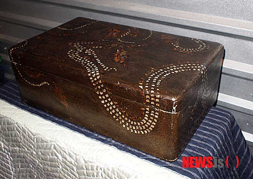 【뉴욕=뉴시스】노창현 특파원 = 최근 뉴욕 메트로폴리탄 박물관에서 임금의 곤룡포를 보관하는 ‘용장식 대례복함’이 발견된데 이어 뉴욕의 골동품 수집가가 유사한 의복함을 갖고 있는 사실이 18일 밝혀졌다. 고미술품 수집가 윤원형씨가 소장한 이 의복함은 두 마리의 용이 여의주를 향해 날아드는 형상에 크기도 비슷하고 용의 발톱이 4개인 사조룡(四爪龍)인 것도 동일하다. 다만 용의 형상과 표현 양식이 다르고 색상이 투박하며 장식도 화려함이 덜했다. 윤씨는 메트뮤지엄의 곤룡포함은 조선 후기에 제작됐지만 자신의 소장품은 초중기에 만들어진 것이어서 용무늬 문양이 바랜 상태라며 재질이 거북이 등껍질과 상어가죽으로 돼 있어 그 가치가 더욱 높다고 주장했다. 2013.07.18. <사진=뉴욕한국일보 제공>&nbsp; robin@newsis.com