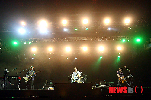 【이천=뉴시스】오제일 기자 = "이 다음 노래는 김광석의 '먼지가 되어'입니다."&nbsp; 미국 얼터너티브 펑크팝 밴드 '위저'가 어눌한 우리말로 다음 곡을 소개하자 2일 '지산 월드 록 페스티벌 2013' 헤드라이너 '위저'의 앙코르 무대를 기다린 수천 팬들은 머리 위로 물음표를 띄웠다.&nbsp; "바흐의 선율에 젖은 날에는/ 잊었던 기억들이 피어나네요/ 바람에 날려간 나의 노래도/ 휘파람 소리로 돌아오네요."&nbsp; 팬들은 탄성과 함성을 내지르며 열광하기 시작했다. 1994년 셀프타이틀 앨범으로 데뷔, 세계에 2000만장 이상의 앨범을 팔아치운 밴드가 '먼지가 되어'를 부르는 순간이다. 공연이 열린 '월드 스테이지' 곳곳에서 '위저'의 선율을 담는 스마트 폰이 반짝였다.&nbsp; "작은 가슴을 모두 모두어/ 시를 써봐도 모자란 당신/ 먼지가 되어 날아가야지/ 바람에 날려 당신 곁으로."&nbsp; '위저'에게는 한국인 친구가 있는 것이 분명했다. 탁월한 선곡에 이은 정확한 발음이다. 보컬 리버스 쿼모(43)는 연습을 거듭한 듯 환호하는 팬들을 응시하며 여유롭게 곡을 소화했다.&nbsp; '위저'의 '한국 맞춤형 공연'은 지산 월드 록 페스티벌이 열리기 전부터 예고됐다. 앞서 위저는 페이스북 계정을 통해 '먼지가 되어'를 소리 나는대로 영어로 옮긴 사진을 게재하며 한국 팬들의 기대를 부풀렸다. 이날 밤 "우리는 위저입니다. 여러분 어디 살아요?"라는 우리말로 무대를 열자 팬들의 기대는 '확신'이 됐다.&nbsp; '언던-더 스웨터 송(Undone-The Sweater Song)'으로 무대를 닫을 때까지 리버스 쿼모, 브라이언 벨(45·기타), 스콧 슈리너(48·베이스), 패트릭 윌슨(44·드럼)은 데뷔 20년차 밴드 '위저'가 여전히 '유쾌한 밴드'임을 증명했다. 특히 보컬 리버스 쿼모는 무대장치를 덮고 있던 방수포를 덮어쓰고 노래하는가 하면 연주 중인 멤버들에게 익살스러운 표정으로 장난을 걸었다.&nbsp; 이미 2002년 한·일 월드컵, 2009년 '지산 밸리 록 페스티벌'때 내한한 '위저'는 공연 내내 "재미있을 거에요." "소리쳐봐요" "따라 하세요" "더 크게" "죽여주죠" 등 한국말로 분위기를 띄웠다. '언던-더 스웨터 송'의 후렴에 밴드 'YB'의 "오 필승 코리아"를 녹여, 웃음도 줬다.&nbsp; 한국팬들도 '위저'의 성의에 화답했다. '퍼펙트 시추에이션' '아일랜드 인 더 선(Island In The Sun)' '버리 홀리' '해시 파이프(Hash Pipe)' 등의 히트곡들로 짠 세트 리스트에 한국팬들은 '환호' '점핑' '떼창'으로 답했다.&nbsp; "또 불러주세요. 언제든지 달려올게요"라는 '위저'의 멘트는 팬들에게 기대감을 안겼다. 다만, 이날 오후 갑작스레 쏟아진 폭우로 공연 스케쥴이 밀리며 90분으로 예고됐던 공연이 70여분 만에 끝난 점, 공연이 연기되며 '피스 스테이지' 무대에 오른 힙합계의 대부 '나스'와 공연시간이 겹쳐 팬들이 양분됐다는 점 등이 아쉬움을 남겼다.&nbsp; 한편, 주최측은 이날 지산 월드 록 페스티벌 입장객을 2만명으로 집계했다.&nbsp; 4일까지 '위저'를 비롯해 '에브리 유 에브리 미(Every You Every Me)'로 유명한 영국의 얼터너티브 록 밴드 '플라시보', '지난 100년간 가장 독창적인 밴드'로 평가받는 19년차 미국 인디밴드 '디어후프', 2008년 첫 내한 공연 티켓을 5분만에 모두 팔아치운 애시드 재즈 밴드 '자미로 콰이' 등이 공연한다. '시나위' '노브레인' '브로콜리 너마저' '허클베리핀' 등 국내 밴드 등도 무대에 오른다.&nbsp; kafka@newsis.com