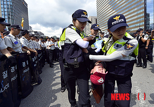 【서울=뉴시스】최동준 기자 = 15일 오후 서울 광화문 네거리 차도에서 한대련 회원들이 '국정원 해체'를 요구하며 기습 시위를 벌이자 경찰이 연행하고 있다. 2013.08.15.&nbsp;&nbsp; photocdj@newsis.com