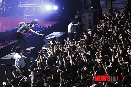 【서울=뉴시스】이재훈 기자 = "아이 갓 솔, 벗 아임 낫 어 솔저. 아 갓 솔, 벗 아임 낫 어 솔저(I got soul, but I'm not a soldier) ♩♬'….&nbsp; '올 디즈 싱스 댓 아이브 돈(Alll these things that I've done)'이 5일 밤 서울 올림픽공원 올림픽홀에서 울려 퍼지자 약 3400명은 모두 약속이나 한 듯 따라 불렀다. 인터넷에서 이벤트를 논의한 일부 팬들은 지퍼 백에 담아온 종이 가루를 노랫말에 맞춰 흩뿌리기도 했다.&nbsp;&nbsp; 미국의 록밴드 '더 킬러스(The Killers)'의 첫 내한공연 '현대카드 컬처프로젝트 12 더 킬러스'는 한바탕 록 페스티벌 전쟁이 벌어진 지난 여름의 어떤 공연에도 뒤지지 않을 만큼 열정적이었다.&nbsp; 2004년 데뷔한 킬러스는 애초 2010년 2월6일 첫 내한공연을 할 예정이었다. 그러나 콘서트를 앞두고 보컬 브랜든 플라워스(32)의 모친이 갑자기 사망하면서 취소됐다.&nbsp; 지난해 발매한 정규앨범 '배틀 본(Battle Born)'을 기념하는 투어인 이번 무대는 그간 3년8개월의 기다림을 불식시키기도 남았다. 데뷔년도로 따지면, 기다림이 9년인데 그 아쉬움도 달래줬다. 예정보다 약 20분 늦은 오후 8시20분부터 90여분간 17곡을 들려주며 사운드를 휘몰아쳤다.&nbsp; '배틀본' 재킷 한가운데는 번개가 박혀 있다. 이번 투어 무대의 플라워스가 사용하는 키보드 앞에도 역시 이 번개와 모양이 같은 전열등이 설치됐다. 공연 내내 붉은 색, 푸른 색 등 시시각각 변하며 분위기를 강렬하게 주도했다. 킬러스는 미국 밴드이나, 브릿팝의 멜로디컬한 세련됨 때문에 영국 밴드로 오해를 받는다. 실제 접한 무대 자체는 미국 록밴드들의 테스토스테론이 풍겨나왔다.&nbsp;&nbsp; 사실 '떼창'은 첫곡부터 시작됐다. 킬러스의 대표곡인 '미스터. 브라이트사이드(Mr. Brightside)'로 예열을 할 필요도 없이 바로 끓는 점으로 돌입했다. 다만 이 곡의 제목처럼 객석의 조명은 꺼지지 않았다. 2번째 곡 '스페이스맨'부터 객석의 조명이 꺼지고, 번개가 반짝이기 시작했다.&nbsp;&nbsp; '프럼 히어 온 아웃'을 부른 뒤에는 다소 엄숙했다. 플라워스가 하늘에 있는 어머니를 떠올렸기 때문이다. 2010년 첫 내한공연을 취소할 수밖에 없었던 이유다. 플라워스는 이어서 부른 '더스트랜드 페어리 테일' 끝에 눈시울을 붉히기도 했다. 이 곡의 노랫말은 그가 자신의 어머니와 아버지를 신데렐라와 미국 왕자에 비유, 일종의 '황무지의 동화'로 풀어냈다.&nbsp;&nbsp; 플라워스는 그래도 공연의 대부분을 화려한 무대 매너로 팬들을 열광케 했다. 이름 때문에 국내 팬들에게 '브랜든 꽃'으로 통하는 그는 여전히 뛰어난 외모와 세련된 패션 감각을 자랑했다. 초반에 다소 컨디션이 좋아 보이지 않았으나, 한국 팬의 인장과도 같은 뜨거운 반응에 점차 기력을 되찾았다. 내내 모니터용 스피커에 올라가면서 고군부투했다. 서툰 한국말로 "음악과 우리는 너의 것이다"라고 말하는 등 팬들과 소통하려는 모습도 인상적이었다.&nbsp; 이날 플라워스 만큼 빛난 것은 드러머 로니 배누치 주니어(36)였다. 한가운데 자신이 이름이 한글로 적힌 검은 반소매 티셔를 입고 등장, 초반부터 팬들의 환심을 산 그는 '파워 드럼'을 보여주면서 존재감을 확실히 했다. 기타리스트 데이브 큐닝(36)도 자기 몫을 묵묵히 해냈다.&nbsp; 다만, 베이시스트 마크 스토머(36)는 개인 사정으로 이번 내한에 함께 하지 못했다. 대신 공식 투어팀의 연주자가 베이스 연주를 맡았다. 묵직한 베이스 리프가 인상적인 '제니 워스 어 프렌드 오브 마인(Jenny was a friend of mine)'를 스토머의 연주로 듣지 못한 점은 아쉬웠지만 공연의 질에는 크게 문제가 없었다.&nbsp; '제니 워스 어 프렌드 오브 마인' '웬 유 아 영' 등을 앙코르로 들려준 킬러스는 가을 밤, 록이 여름의 전유물이 아니라는 것을 증명했다. 무대 위 번개는 같은 시간 벌어진 '여의도 불꽃 축제'만큼 번쩍였다.&nbsp; 공연에 앞서 실험적이면서도 서정적인 사운드를 선보이는 인디밴드 '3호선 버터플라이'가 오프닝 무대를 꾸몄다. 보컬 남상아(40)는 '헤어지는 날 바로 오늘' '내가 고백을 하면 깜짝 놀랄거야'에서 카리스마를 뽐내며, 킬러스를 기다리던 팬들의 설렘을 달랬다.&nbsp; <사진> 현대카드&nbsp;&nbsp; realpaper7@newsis.com 