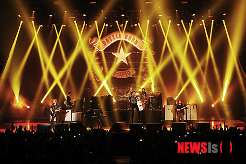 【서울=뉴시스】이재훈 기자 = "아이 갓 솔, 벗 아임 낫 어 솔저. 아 갓 솔, 벗 아임 낫 어 솔저(I got soul, but I'm not a soldier) ♩♬'….&nbsp; '올 디즈 싱스 댓 아이브 돈(Alll these things that I've done)'이 5일 밤 서울 올림픽공원 올림픽홀에서 울려 퍼지자 약 3400명은 모두 약속이나 한 듯 따라 불렀다. 인터넷에서 이벤트를 논의한 일부 팬들은 지퍼 백에 담아온 종이 가루를 노랫말에 맞춰 흩뿌리기도 했다.&nbsp;&nbsp; 미국의 록밴드 '더 킬러스(The Killers)'의 첫 내한공연 '현대카드 컬처프로젝트 12 더 킬러스'는 한바탕 록 페스티벌 전쟁이 벌어진 지난 여름의 어떤 공연에도 뒤지지 않을 만큼 열정적이었다.&nbsp; 2004년 데뷔한 킬러스는 애초 2010년 2월6일 첫 내한공연을 할 예정이었다. 그러나 콘서트를 앞두고 보컬 브랜든 플라워스(32)의 모친이 갑자기 사망하면서 취소됐다.&nbsp; 지난해 발매한 정규앨범 '배틀 본(Battle Born)'을 기념하는 투어인 이번 무대는 그간 3년8개월의 기다림을 불식시키기도 남았다. 데뷔년도로 따지면, 기다림이 9년인데 그 아쉬움도 달래줬다. 예정보다 약 20분 늦은 오후 8시20분부터 90여분간 17곡을 들려주며 사운드를 휘몰아쳤다.&nbsp; '배틀본' 재킷 한가운데는 번개가 박혀 있다. 이번 투어 무대의 플라워스가 사용하는 키보드 앞에도 역시 이 번개와 모양이 같은 전열등이 설치됐다. 공연 내내 붉은 색, 푸른 색 등 시시각각 변하며 분위기를 강렬하게 주도했다. 킬러스는 미국 밴드이나, 브릿팝의 멜로디컬한 세련됨 때문에 영국 밴드로 오해를 받는다. 실제 접한 무대 자체는 미국 록밴드들의 테스토스테론이 풍겨나왔다.&nbsp;&nbsp; 사실 '떼창'은 첫곡부터 시작됐다. 킬러스의 대표곡인 '미스터. 브라이트사이드(Mr. Brightside)'로 예열을 할 필요도 없이 바로 끓는 점으로 돌입했다. 다만 이 곡의 제목처럼 객석의 조명은 꺼지지 않았다. 2번째 곡 '스페이스맨'부터 객석의 조명이 꺼지고, 번개가 반짝이기 시작했다.&nbsp;&nbsp; '프럼 히어 온 아웃'을 부른 뒤에는 다소 엄숙했다. 플라워스가 하늘에 있는 어머니를 떠올렸기 때문이다. 2010년 첫 내한공연을 취소할 수밖에 없었던 이유다. 플라워스는 이어서 부른 '더스트랜드 페어리 테일' 끝에 눈시울을 붉히기도 했다. 이 곡의 노랫말은 그가 자신의 어머니와 아버지를 신데렐라와 미국 왕자에 비유, 일종의 '황무지의 동화'로 풀어냈다.&nbsp;&nbsp; 플라워스는 그래도 공연의 대부분을 화려한 무대 매너로 팬들을 열광케 했다. 이름 때문에 국내 팬들에게 '브랜든 꽃'으로 통하는 그는 여전히 뛰어난 외모와 세련된 패션 감각을 자랑했다. 초반에 다소 컨디션이 좋아 보이지 않았으나, 한국 팬의 인장과도 같은 뜨거운 반응에 점차 기력을 되찾았다. 내내 모니터용 스피커에 올라가면서 고군부투했다. 서툰 한국말로 "음악과 우리는 너의 것이다"라고 말하는 등 팬들과 소통하려는 모습도 인상적이었다.&nbsp; 이날 플라워스 만큼 빛난 것은 드러머 로니 배누치 주니어(36)였다. 한가운데 자신이 이름이 한글로 적힌 검은 반소매 티셔를 입고 등장, 초반부터 팬들의 환심을 산 그는 '파워 드럼'을 보여주면서 존재감을 확실히 했다. 기타리스트 데이브 큐닝(36)도 자기 몫을 묵묵히 해냈다.&nbsp; 다만, 베이시스트 마크 스토머(36)는 개인 사정으로 이번 내한에 함께 하지 못했다. 대신 공식 투어팀의 연주자가 베이스 연주를 맡았다. 묵직한 베이스 리프가 인상적인 '제니 워스 어 프렌드 오브 마인(Jenny was a friend of mine)'를 스토머의 연주로 듣지 못한 점은 아쉬웠지만 공연의 질에는 크게 문제가 없었다.&nbsp; '제니 워스 어 프렌드 오브 마인' '웬 유 아 영' 등을 앙코르로 들려준 킬러스는 가을 밤, 록이 여름의 전유물이 아니라는 것을 증명했다. 무대 위 번개는 같은 시간 벌어진 '여의도 불꽃 축제'만큼 번쩍였다.&nbsp; 공연에 앞서 실험적이면서도 서정적인 사운드를 선보이는 인디밴드 '3호선 버터플라이'가 오프닝 무대를 꾸몄다. 보컬 남상아(40)는 '헤어지는 날 바로 오늘' '내가 고백을 하면 깜짝 놀랄거야'에서 카리스마를 뽐내며, 킬러스를 기다리던 팬들의 설렘을 달랬다.&nbsp; <사진> 현대카드&nbsp;&nbsp; realpaper7@newsis.com 