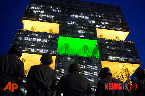 【리우데자네이루=AP/뉴시스】브라질 시위대가 21일(현지시간) 리우데자네이루에 있는 국영석유회사 패트로브라스 본사에서 리브라 광구 심해유전 개발 국제입찰에 항의하고 있고 경찰이 건물 밖에서 지키고 서 있다. 개발 가능한 석유 매장량이 약 120억 배럴에 달하는 것으로 추정되는 리브라 광구에 대한 개발권이 이날 브라질·영국·네덜란드·프랑스·중국 등 5개국 컨소시엄에 돌아갔다. 2013.10.22