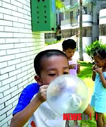 【서울=뉴시스】중국 아이들이 콘돔으로 풍선 장난을 하고 있다. 정부의 산아제한 정책 시행으로 보건 당국은 콘돔을 가정에 대량 무료 배분하거나 병원을 통해 배포하는 경우가 많아 아이들이 접하는 경우가 많고, 장난감으로 가지고 노는 현상도 흔하다. 이 가운데 최근 한 중학생이 병원에서 무료로 배포한 콘돔을 학교에 가져와 풍선처럼 불었다고 경고 처벌을 받아 논란이 일고 있다. (사진 출처: 바이두) 