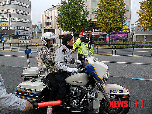 【대구=뉴시스】김태원 기자 = 2014년도 대학수학능력시험일인 7일 오전 대구시 중구 남산동 경북여고 앞에서 응시장을 잘못 찾은 수험생을 위해 중부경찰서 교통안전계 김성수 경사가 경찰 오토바이를 이용해 응시장으로 바래다주고 있다. 2013.11.07 bplace27@newsis.com