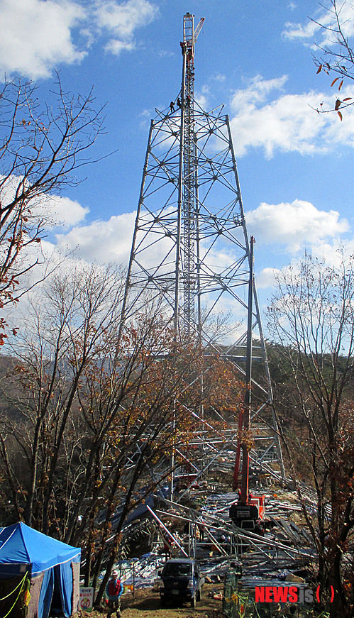 【밀양=뉴시스】안지율 기자 = 18일 한국전력공사가 시행하는 경남 밀양시 단장면 고례리 84번 송전탑 현장에서 시공사 직원들이 송전탑 104m 중 65m의 철탑 조립작업으로 상부 철탑 모습이 드러나고 있다. 이날 철탑 조립 작업이 한창 진행 중인 이 철탑은 이달 말께 공사가 완료될 예정이다. 2013.11.18.&nbsp; alk9935@newsis.com 