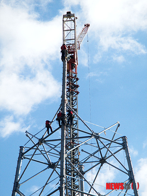 【밀양=뉴시스】안지율 기자 = 18일 한국전력공사가 시행하는 경남 밀양시 단장면 고례리 84번 송전탑 현장에서 시공사 직원들이 송전탑 104m 중 65m의 철탑 조립작업으로 상부 철탑 모습이 드러나고 있다. 이날 철탑 조립 작업이 한창 진행 중인 이 철탑은 이달 말께 공사가 완료될 예정이다. 2013.11.18.&nbsp; alk9935@newsis.com 