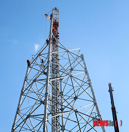 【밀양=뉴시스】안지율 기자 = 18일 한국전력공사가 시행하는 경남 밀양시 단장면 고례리 84번 송전탑 현장에서 시공사 직원들이 송전탑 104m 중 65m의 철탑 조립작업으로 상부 철탑 모습이 드러나고 있다. 이날 철탑 조립 작업이 한창 진행 중인 이 철탑은 이달 말께 공사가 완료될 예정이다. 2013.11.18.&nbsp; alk9935@newsis.com 