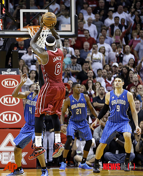 【마이애미=AP/뉴시스】마이애미 히트의 르브론 제임스(사진 가운데)가 24일(한국시간) 미국 플로리다주 마이애미의 아메리칸 에어라인스 아레나에서 열린 2013~2014 미국프로농구(NBA) 올랜도 매직과의 경기에서 4쿼터에 슛을 시도하고 있다.