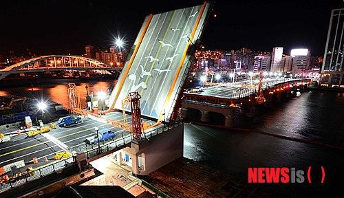 【부산=뉴시스】 하경민 기자 = 한국 현대사의 애환을 담고 있는 부산 영도대교가 47년 만에 도개 기능이 복원돼 27일 개통식을 갖는다. 개통식을 하루 앞둔 26일 새벽 복원된 영도대교에서 차량을 통제한 채 상판을 들어 올리는 도개 테스트가 진행되고 있다. 국내 유일의 도개 기능을 가진 교량인 영도대교는 개통식 이후 매일 낮 12시부터 15분간 상판을 들어올린다. 2013.11.26. yulnetphoto@newsis.com