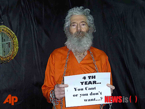 【워싱턴=AP/뉴시스】지난 2007년 3월 이란 키시섬에서 사라진 미 연방수사국(FBI) 요원 출신 로버트 레빈슨이 수염이 더부룩한 모습으로 '4년이 지났다, 당신들은 나를 구할 수 없는 것인가 나를 버린 것인가'라는 문구가 적인 종이를 들고 있다. 이 사진은 2011년 4월 이메일로 레빈슨 가족에 전달됐다. 최근 레빈슨 실종 사건에 미 중앙정보국(CIA)가 연루됐다는 주장이 제기된 가운데 존 매케인 공화당 상원의원이 CIA가 해당사안에 대해 미 의회에 진실을 말하지 않았다고 비난했다. 그동안 미 정부는 레빈슨의 실종에 관해 개인적인 사업 관련 출장을 갔다가 실종됐다고 주장했지만 AP통신은 취재를 통해 그가 CIA의 의뢰로 비공식적인 정보 수집 활동을 하고 있었다고 밝혔다. 2013.12.16 